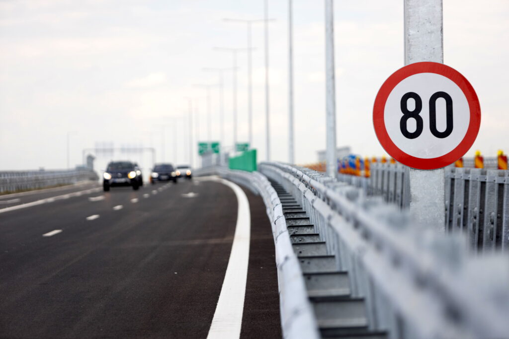 Indicator cu limita de viteza 80 km/h amplasat pe marginea unui drum