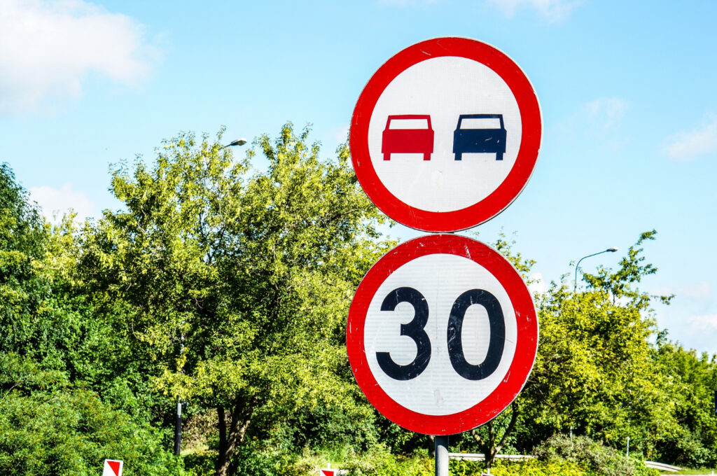 indicator cu limita de viteza de 30 km/h sub unul care interzice depasirea
