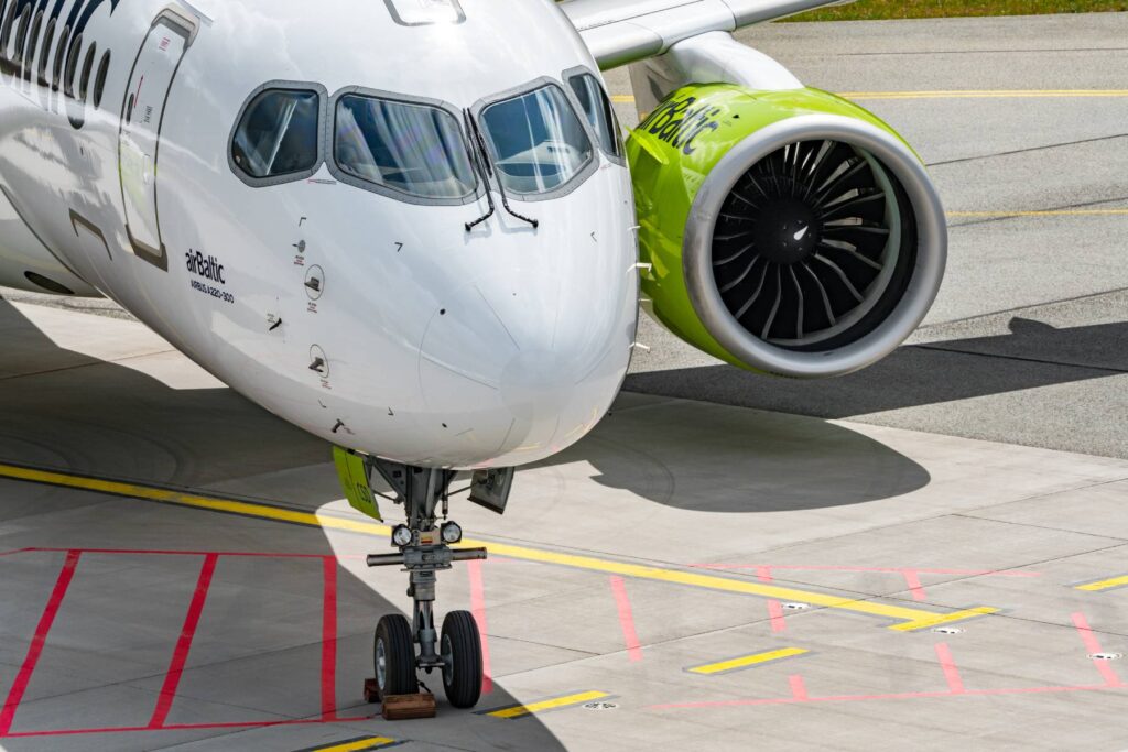 Un avion al companiei airBaltic este fotografia pe pista unui aeroport